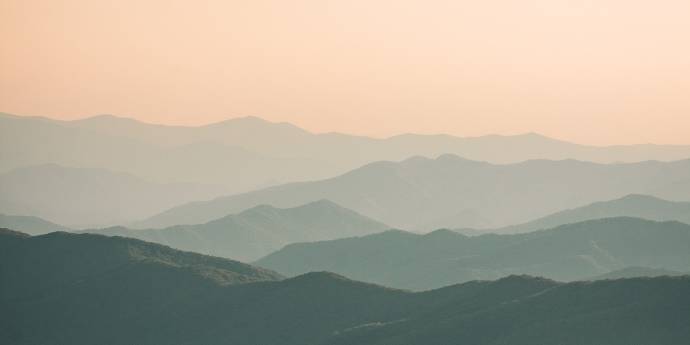 Series of hills fading into hazy sunset