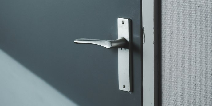 Close up of a door handle on blue door