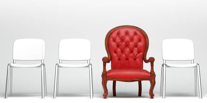 three white chairs and on red chair lined up in a row