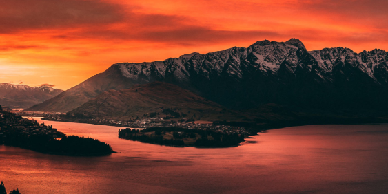 View of mountain over water during an orange sunset