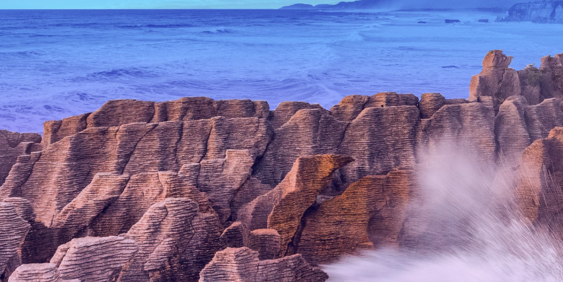 Waves crashing against a rocky shore in New Zealand