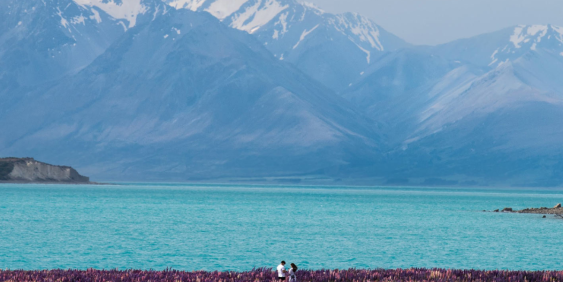 View of snow on mountainside over a lake
