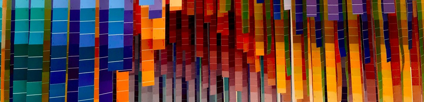 A vibrant wall featuring an array of colorful squares in various shades and sizes, creating a lively visual display.