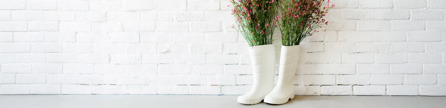  A pair of white boots filled with colorful flowers, showcasing a vibrant and whimsical design.