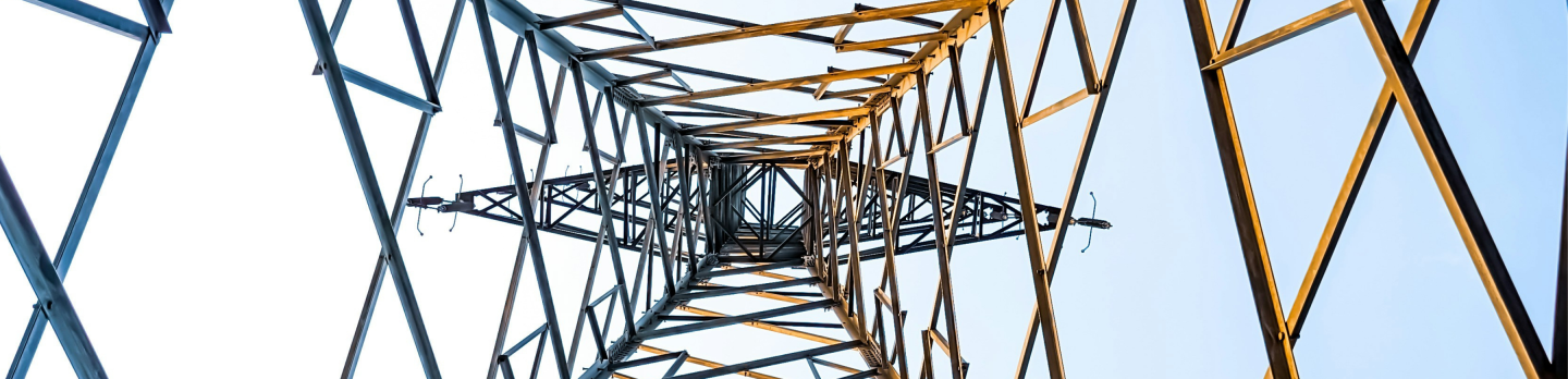 An electrical tower stands tall against a clear blue sky, showcasing its structure and the vastness of the atmosphere.