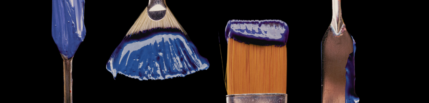 A collection of paint brushes in various colors, arranged together on a surface, showcasing their vibrant bristles.