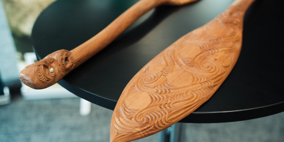 Two wooden paddles resting on a table, showcasing their smooth surfaces and natural grain patterns.