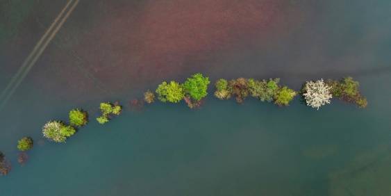 A group of people seated in chairs inside a garage, engaged in conversation and sharing ideas