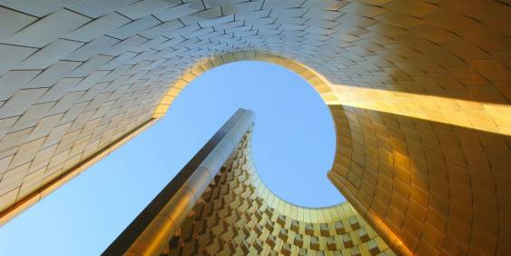 A golden metal building mirrors the sky above, showcasing a beautiful interplay of color and light.