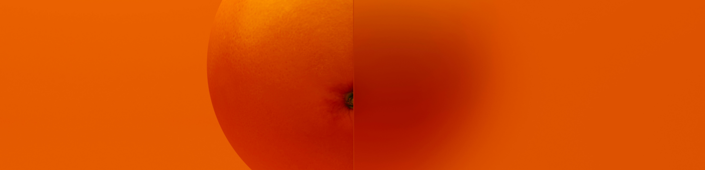 An orange is positioned centrally, with half of it clear and the other half blurred.