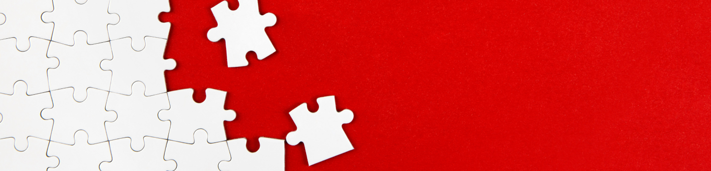 A red and white puzzle piece positioned against a solid red background.
