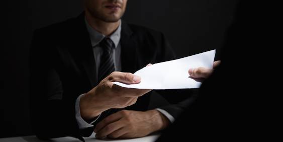 Man handing over a document to another person
