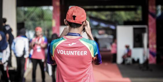 Volunteer worker in a pink shirt and back turned