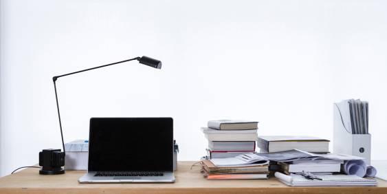 computer, light stand and books on a desk