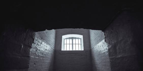 looking up at a window in an old dark abandoned building 