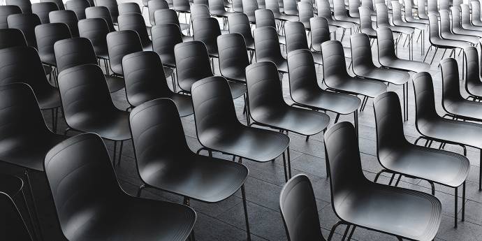 Empty black plastic chairs in rows