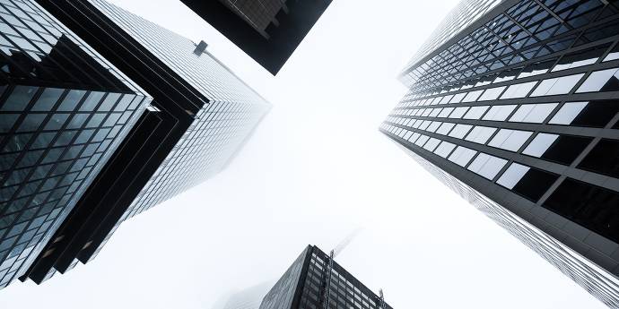 looking up at four office buildings and sky