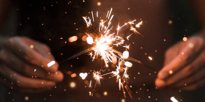 close up images of someone holding a lit sparkler