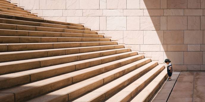 Small boy standing at the foot of wide steps