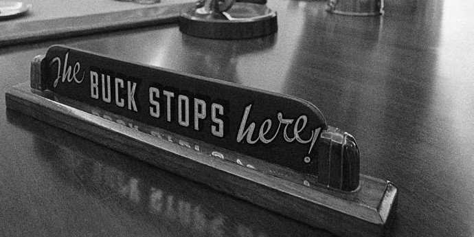 Desk sign with printed words the buck stops here!