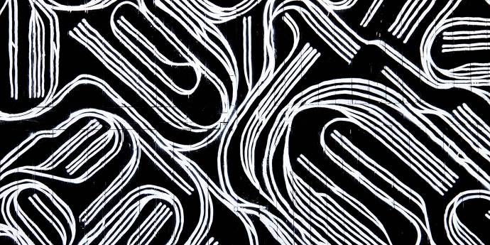white thread in a pattern on black background 