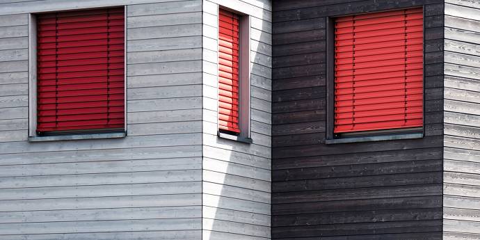 grey building red shutters