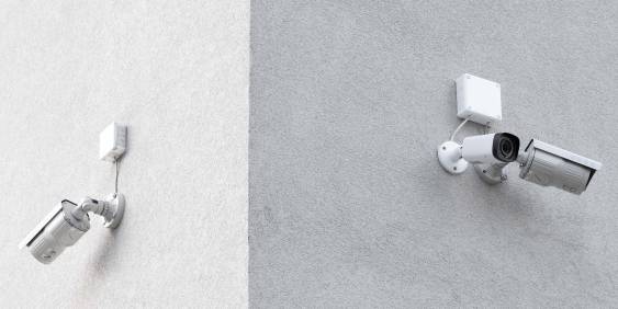 Two grey security cameras on a wall