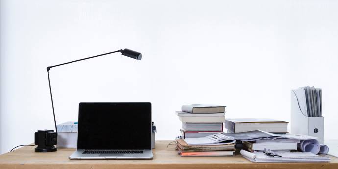 computer, light stand and books on a desk