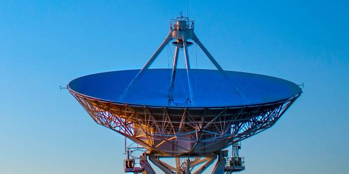 Commercial satellite dish pointing towards a blue sky