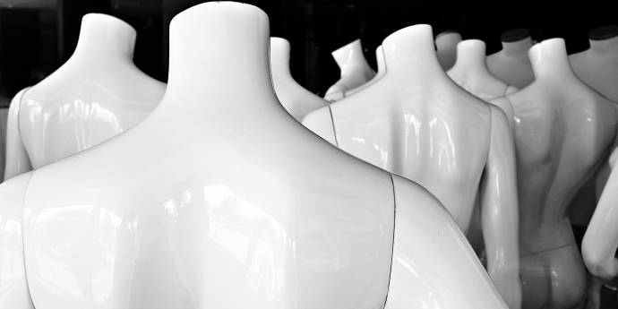 White mannequins with their backs facing us. 