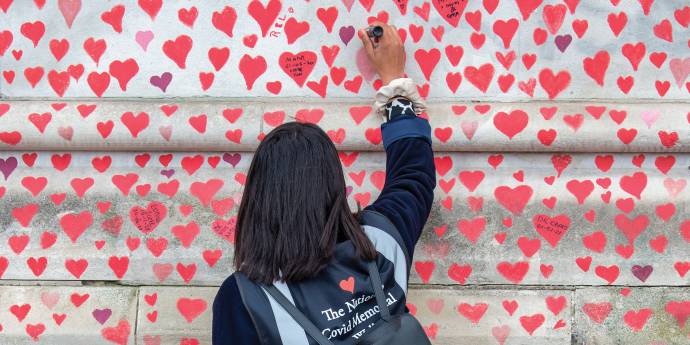 A girl painting red hearts on a wall