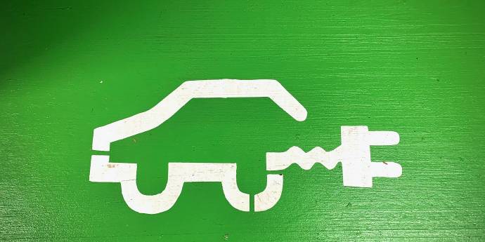 stencil painting of a car with electric plug on green wall