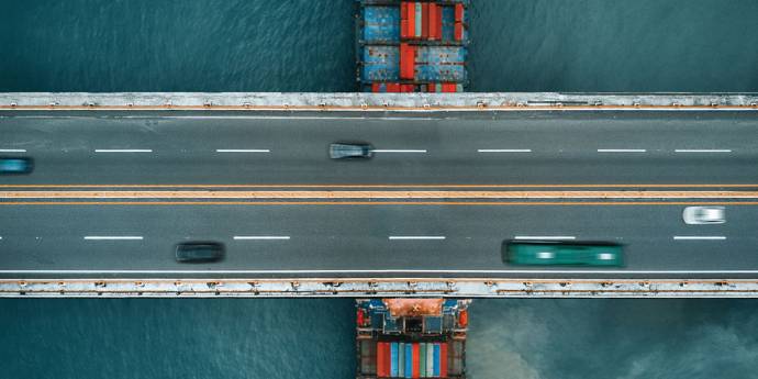 Cargo ship underneath and a bridge road