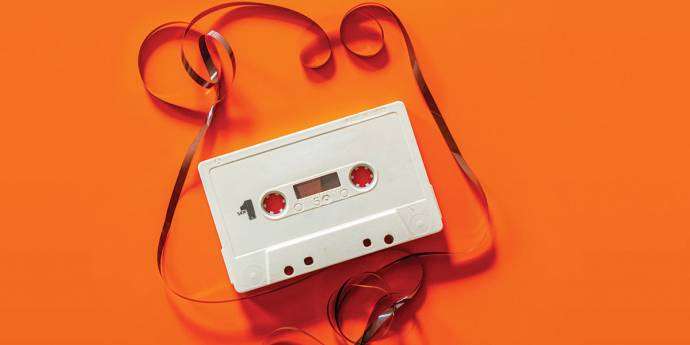 Unraveled cassette tape on a orange background