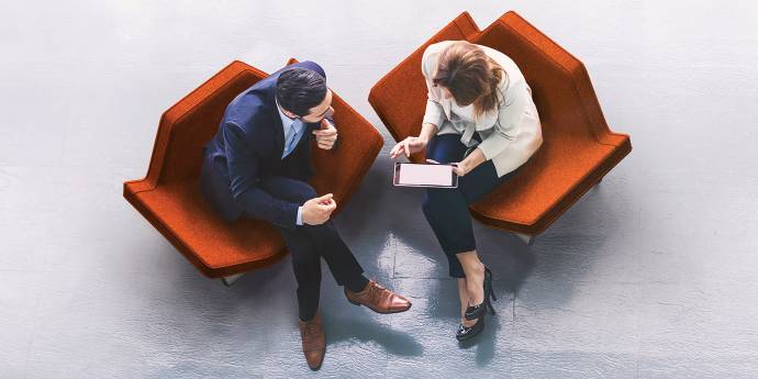 Two business people seated looking at tablet