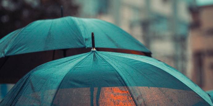 Two green umbrellas in the rain