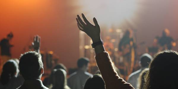 people waving their hands in the air at a concert