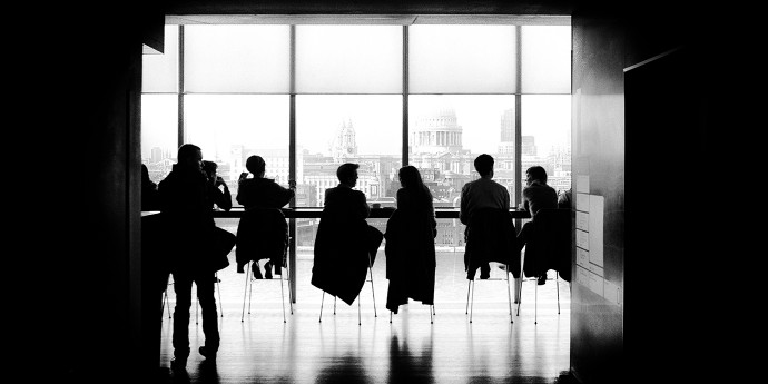 silhouettes seated at table in discussion