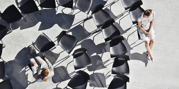 Two women sitting in a circle of chairs