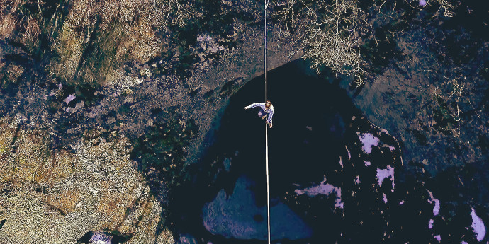 Man on a tightrope over a ravine